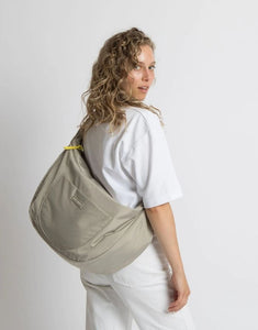 Padded Hip Bag Oversized von Vivi Mari in Stone, große wasserabweisende Umhängetasche mit zwei Außentaschen, verstellbarem Schultergurt und silbernen Metallakzenten, aus recyceltem Polyester.