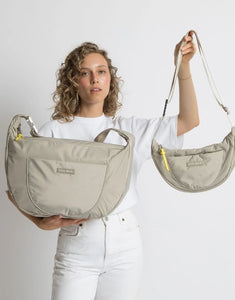 Padded Hip Bag Oversized von Vivi Mari in Stone, große wasserabweisende Umhängetasche mit zwei Außentaschen, verstellbarem Schultergurt und silbernen Metallakzenten, aus recyceltem Polyester.