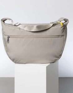 Padded Hip Bag Oversized von Vivi Mari in Stone, große wasserabweisende Umhängetasche mit zwei Außentaschen, verstellbarem Schultergurt und silbernen Metallakzenten, aus recyceltem Polyester.