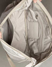 Laden Sie das Bild in den Galerie-Viewer, Padded Hip Bag Oversized von Vivi Mari in Stone, große wasserabweisende Umhängetasche mit zwei Außentaschen, verstellbarem Schultergurt und silbernen Metallakzenten, aus recyceltem Polyester.
