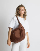 Laden Sie das Bild in den Galerie-Viewer, Padded Hip Bag Oversized von Vivi Mari in Tan, große wasserabweisende Umhängetasche mit zwei Außentaschen, verstellbarem Schultergurt und silbernen Metallakzenten, aus recyceltem Polyester.
