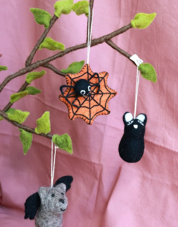 Orangefarbenes Halloween Spinnennetz von Gry &  Sif aus gefilzter Wolle mit kleiner Spinne, handgefertigt, 8 × 8 cm. an einem Zweig