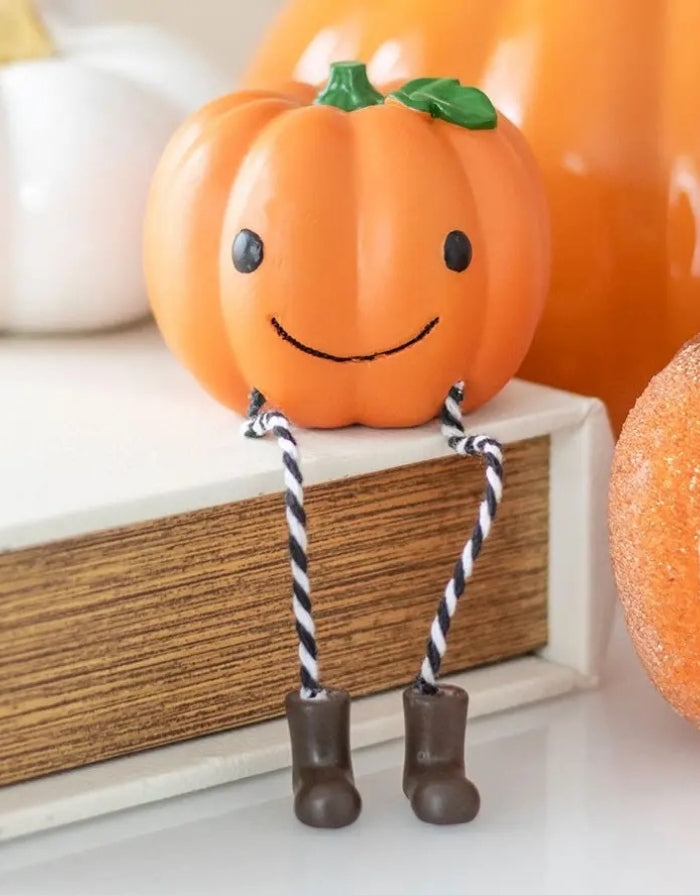 Halloween Kürbis Kantenhocker aus Harz mit freundlichem Gesicht, gestreiften Beinen und kleinen Stiefeln auf einer Kante