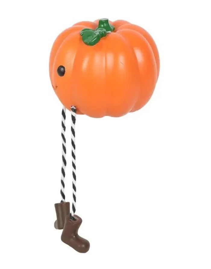 Halloween Kürbis Kantenhocker aus Harz mit freundlichem Gesicht, gestreiften Beinen und kleinen Stiefeln als Freisteller von der Seite