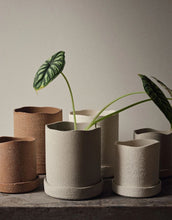Laden Sie das Bild in den Galerie-Viewer, Brauner Übertopf Uneru von Ferm Living mit rauer Oberfläche, unregelmäßigen Kanten und passender Untertasse aus recyceltem Steingut, innen glasiert.
