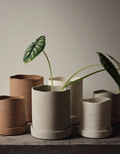 Brauner Übertopf Uneru von Ferm Living mit rauer Oberfläche, unregelmäßigen Kanten und passender Untertasse aus recyceltem Steingut, innen glasiert.