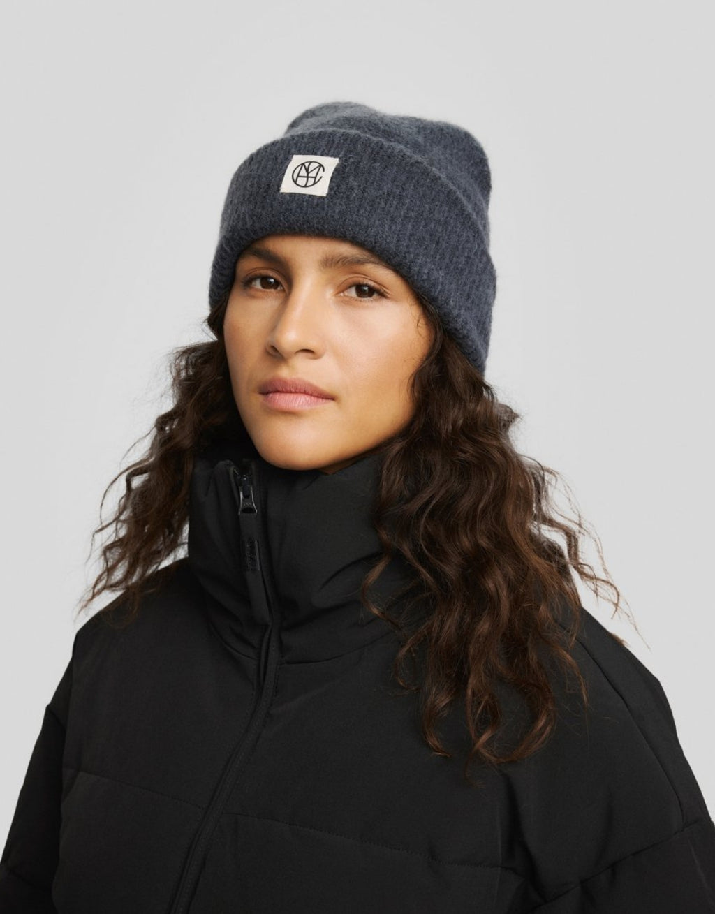  Hope Icon Beanie von MSCH Copenhagen aus weichem Woll- und Alpakamix in India Ink mit gerippter Strickstruktur, breitem Umschlag und dezentem Logo-Patch am Model