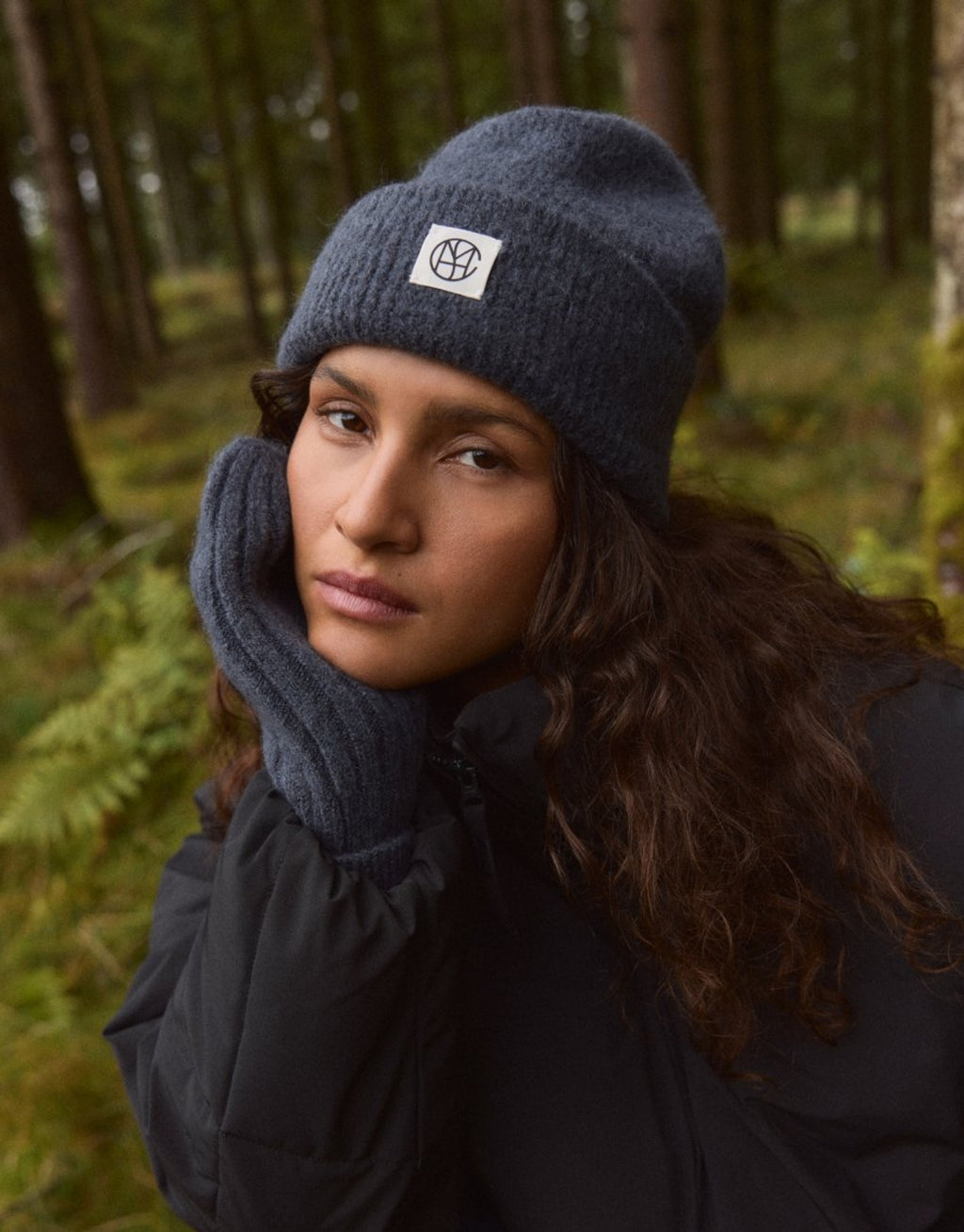 Hope Icon Beanie von MSCH Copenhagen aus weichem Woll- und Alpakamix in India Ink mit gerippter Strickstruktur, breitem Umschlag und dezentem Logo-Patch am Model mit Handschuhen