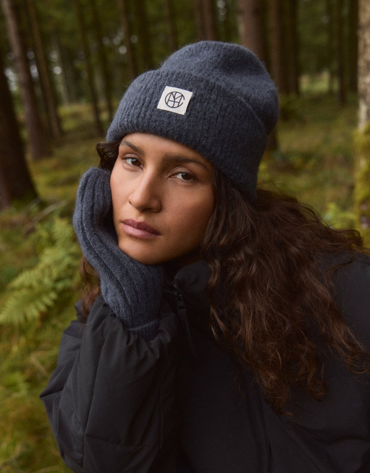Hope Icon Beanie von MSCH Copenhagen aus weichem Woll- und Alpakamix in India Ink mit gerippter Strickstruktur, breitem Umschlag und dezentem Logo-Patch am Model mit Handschuhen