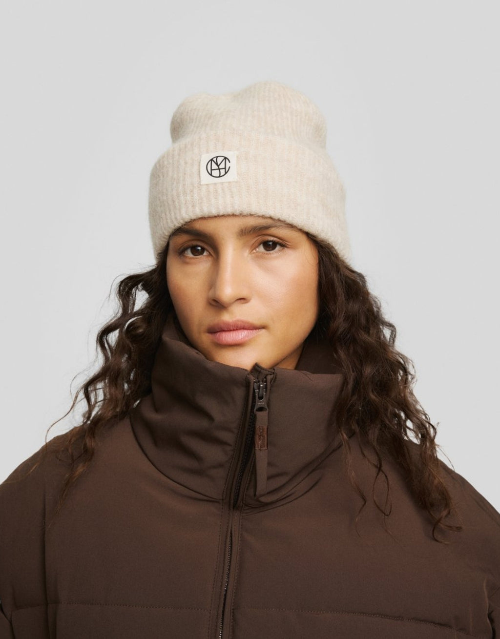 Hope Icon Beanie in der Farbe Oatmeal Melange von MSCH Copenhagen aus weichem Woll- und Alpakamix mit gerippter Strickstruktur, breitem Umschlag und dezentem Logo-Patch am Model