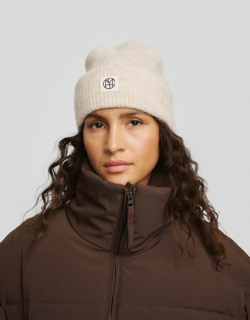 Hope Icon Beanie in der Farbe Oatmeal Melange von MSCH Copenhagen aus weichem Woll- und Alpakamix mit gerippter Strickstruktur, breitem Umschlag und dezentem Logo-Patch am Model