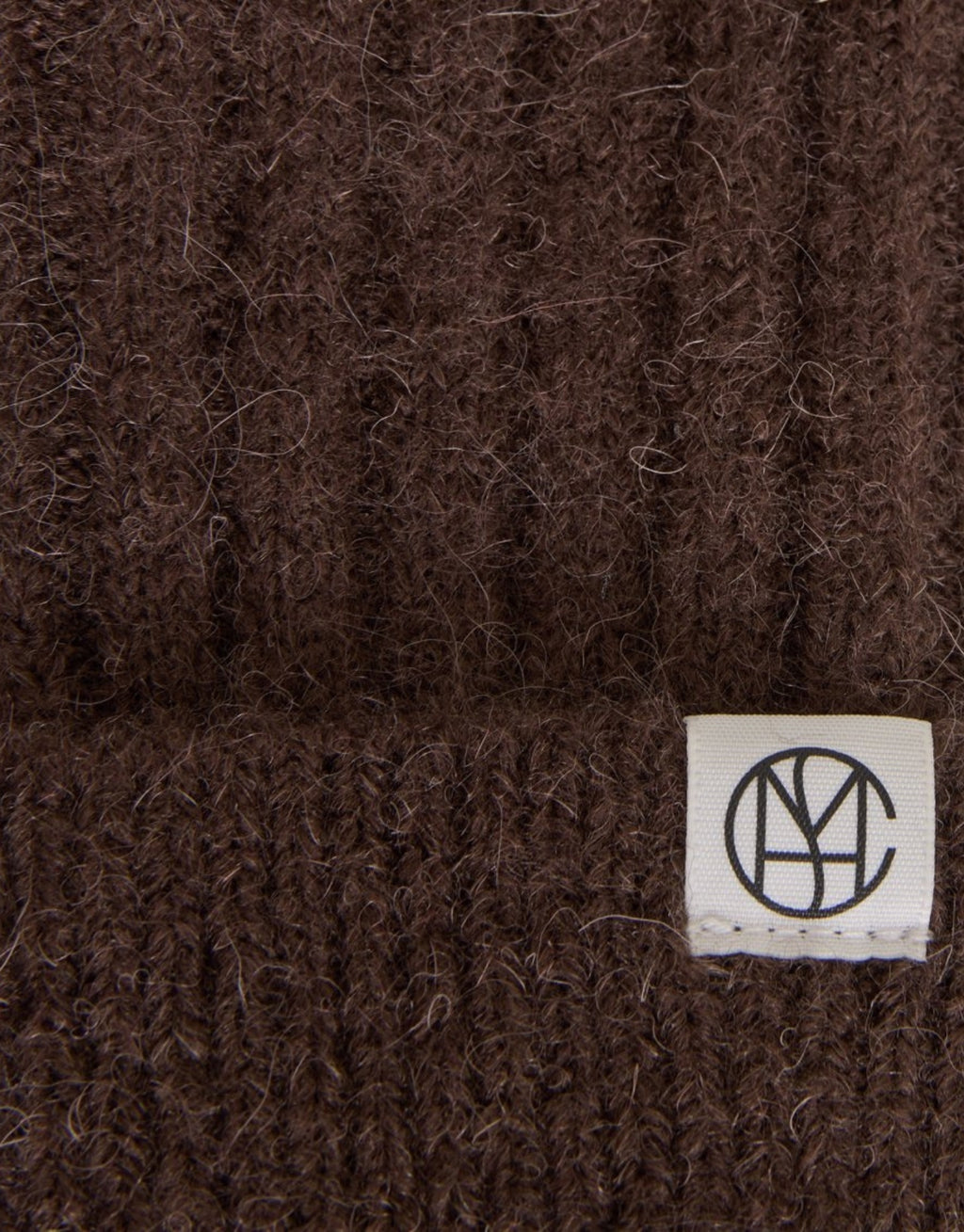 Braune Hope Icon Handschuhe von MSCH Copenhagen aus weichem Woll- und Alpakamix mit gerippter Strickstruktur, umgeschlagenen Bündchen und dezentem Logo-Etikett im Detail