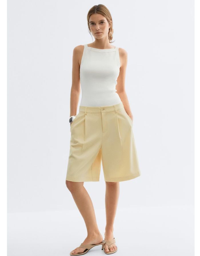 Gina Tricot Bermuda Shorts Butter Yellow mit geradem Bein und Bügelfalten in knielanger Passform an Model von vorne