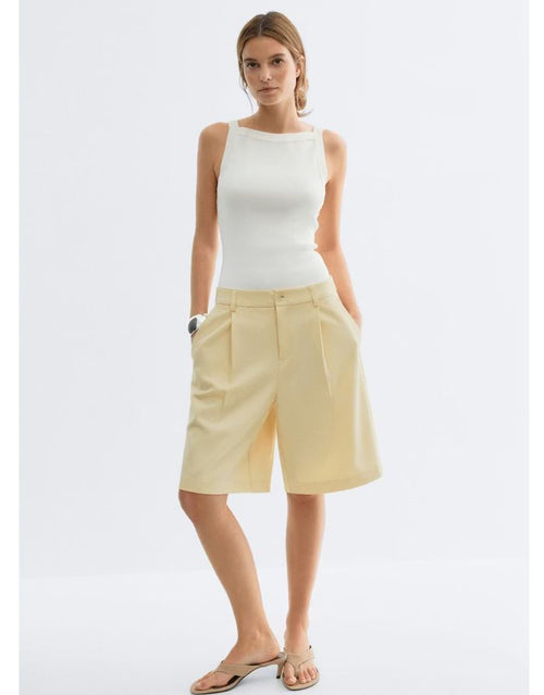 Gina Tricot Bermuda Shorts Butter Yellow mit geradem Bein und Bügelfalten in knielanger Passform an Model von vorne