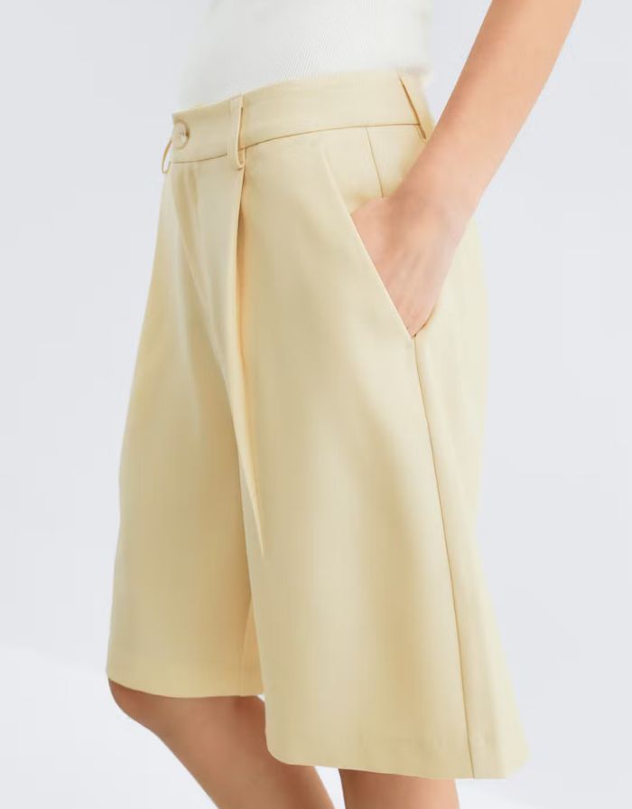 Gina Tricot Bermuda Shorts Butter Yellow mit geradem Bein und Bügelfalten in knielanger Passform von der Seite