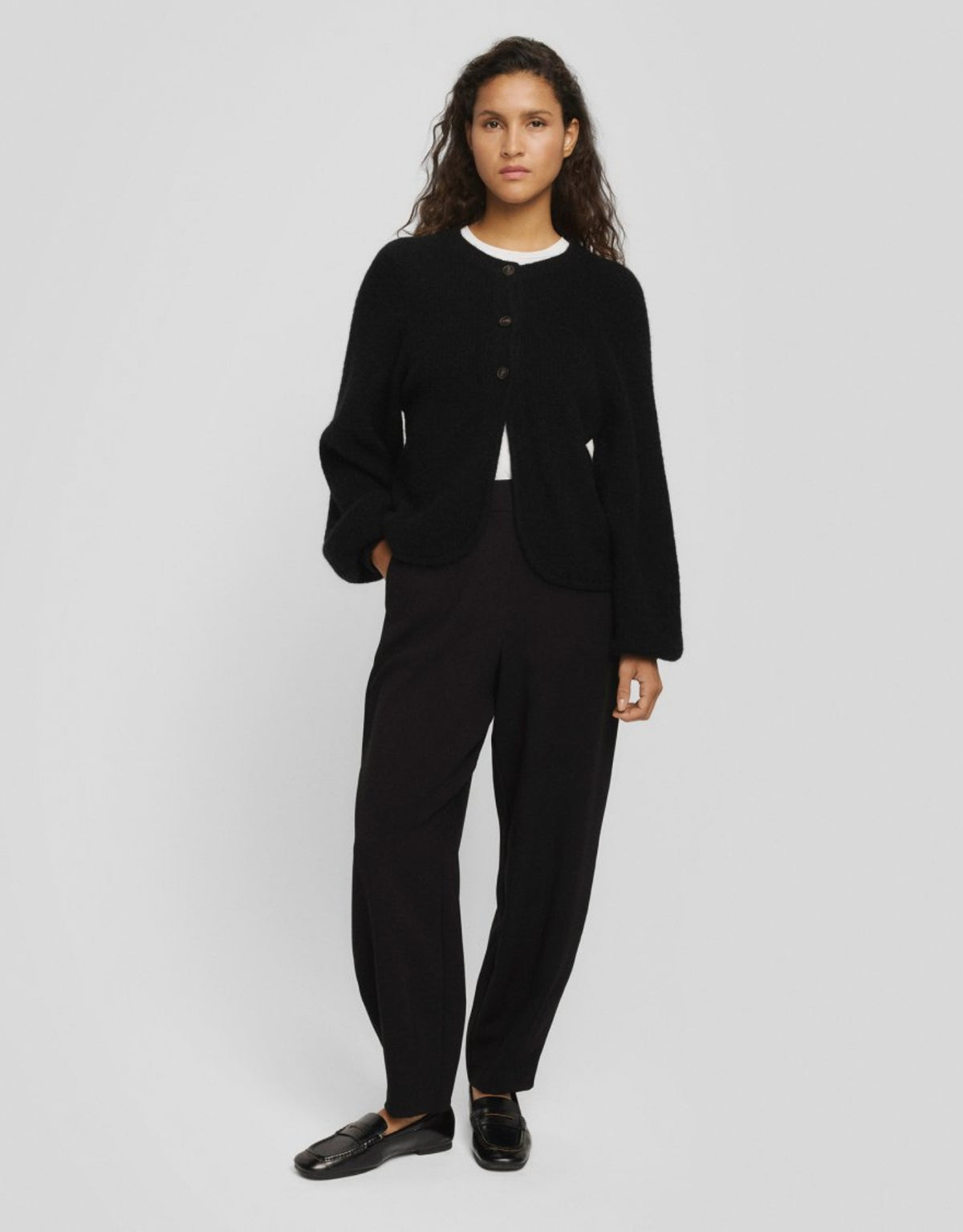 Schwarzer Cilia Hope Cardigan von MSCH Copenhagen aus weichem Woll-Alpaka-Mix mit Rundhalsausschnitt, drei Knöpfen und abgerundeter Vorderseite am  Model