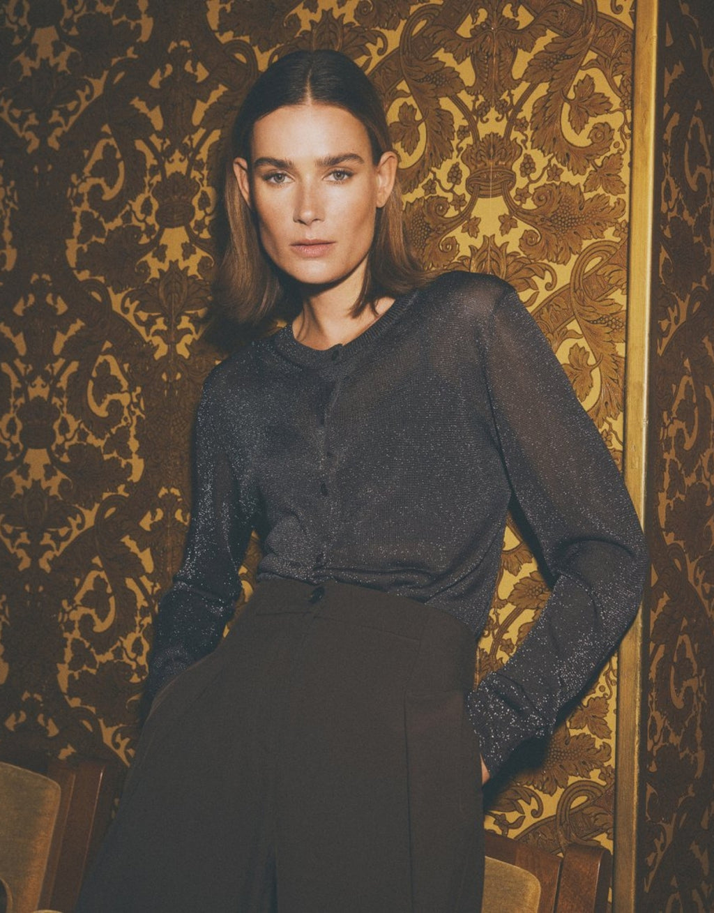 Dunkelbrauner Shirley Cardigan von MSCH Copenhagen aus leicht transparentem Feinstrick mit dezentem Lurex-Glanz, Rundhalsausschnitt und durchgehender Knopfleiste am Model im stehen