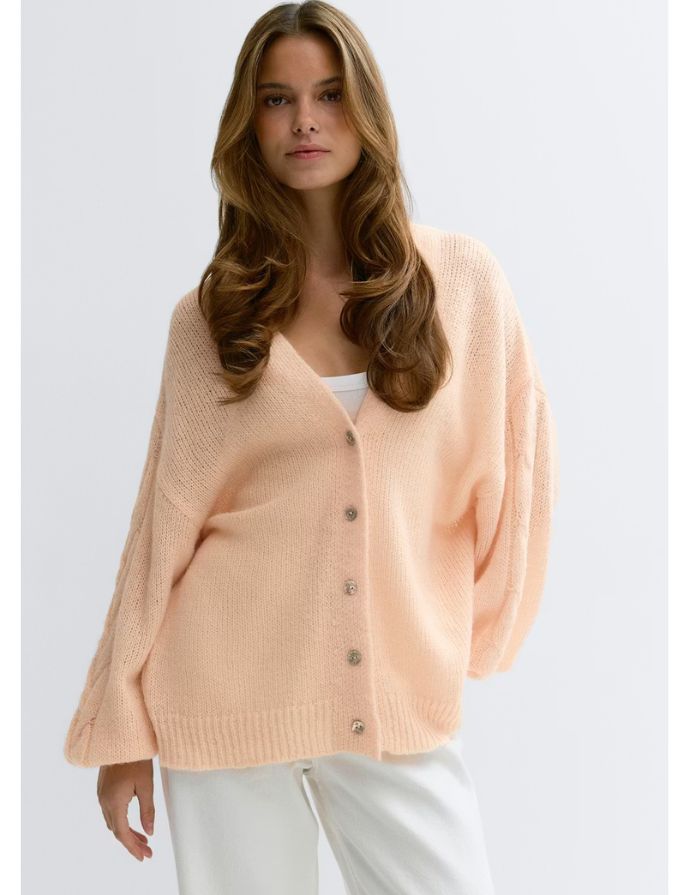 Gina Tricot Oversize Strickjacke Bellini in Pfirsich mit V-Ausschnitt und Knopfleiste an Model von vorne