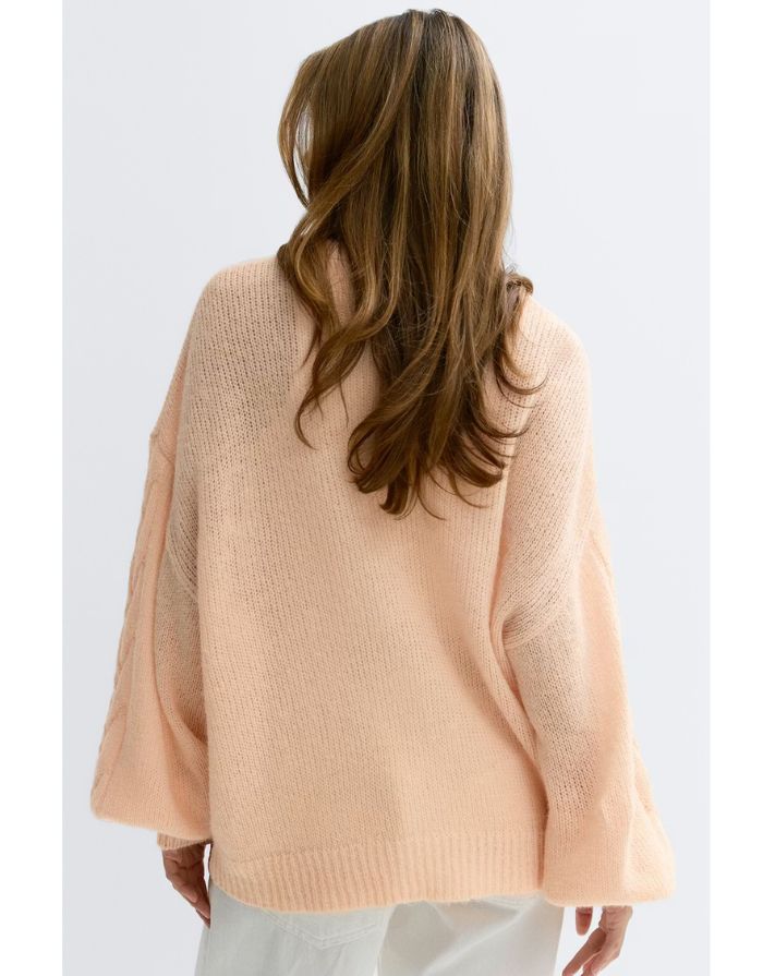 Gina Tricot Oversize Strickjacke Bellini in Pfirsich mit V-Ausschnitt und Knopfleiste an Model von hinten