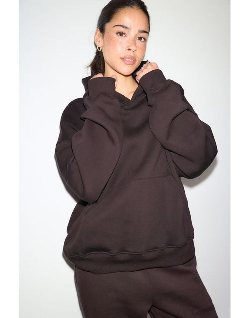 Gina Tricot Iconic Hoodie in Chocolate Plum mit Oversize-Passform, Kängurutasche und gefütterter Kapuze am Model von vorne