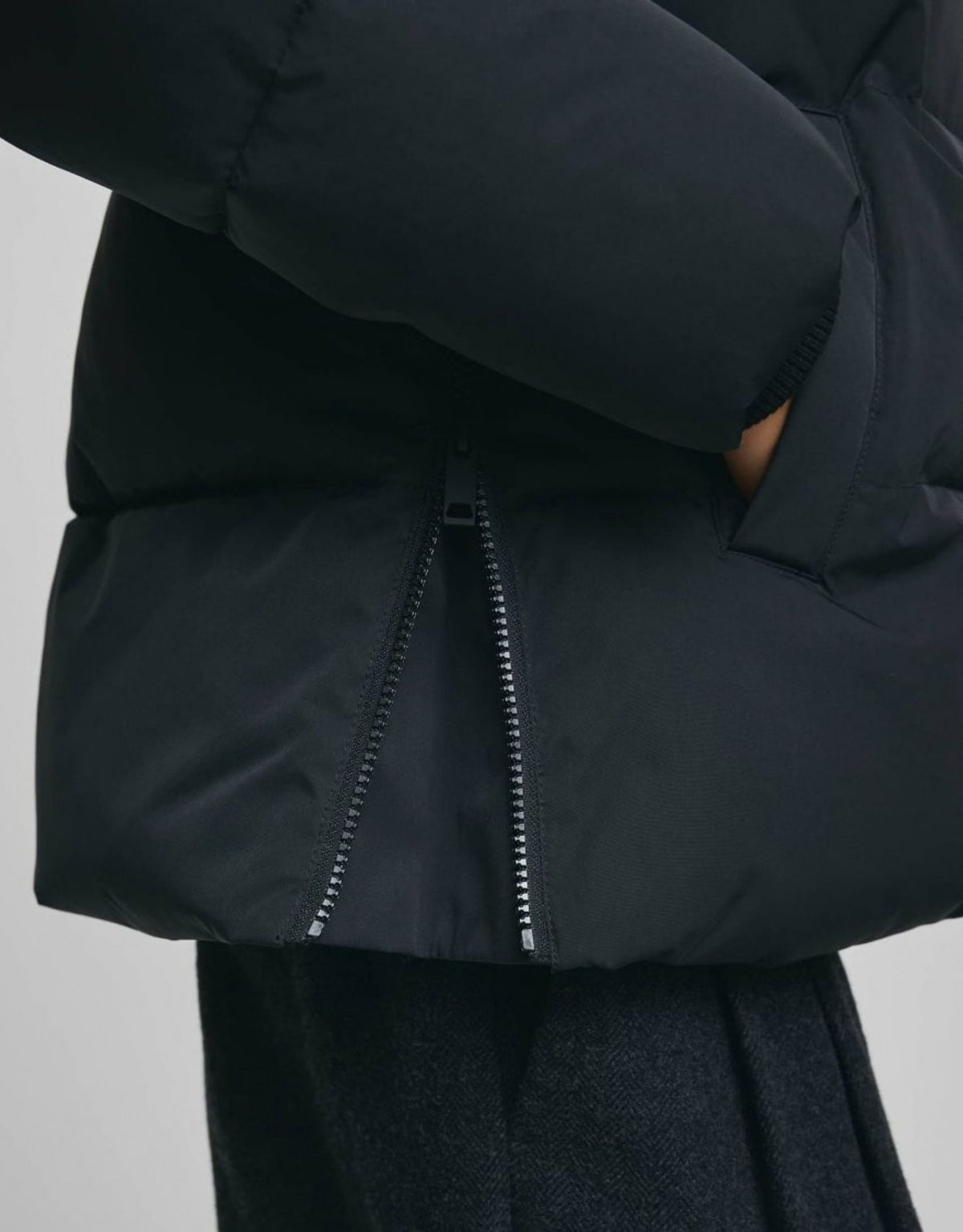 Schwarze kurze Winterjacke Pavinaria Short von MSCH Copenhagen mit Kapuze, hohem Kragen, leichter Wattierung und seitlichen Reißverschlüssen.