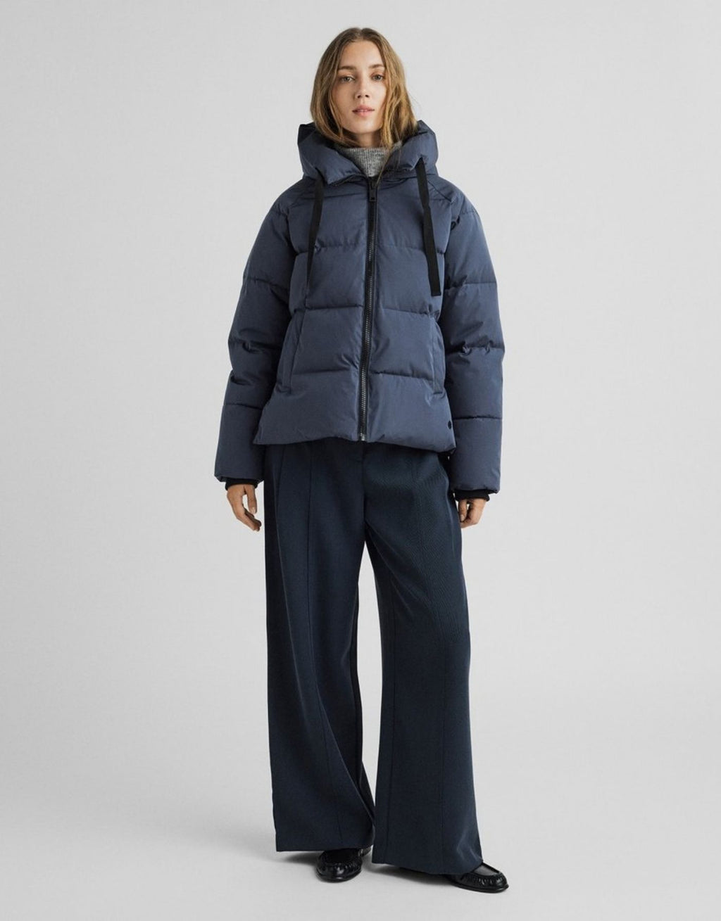 Dunkelblaue kurze Winterjacke Pavinaria Short von MSCH Copenhagen in India Ink mit Kapuze, hohem Kragen, leichter Wattierung und seitlichen Reißverschlüssen am Model