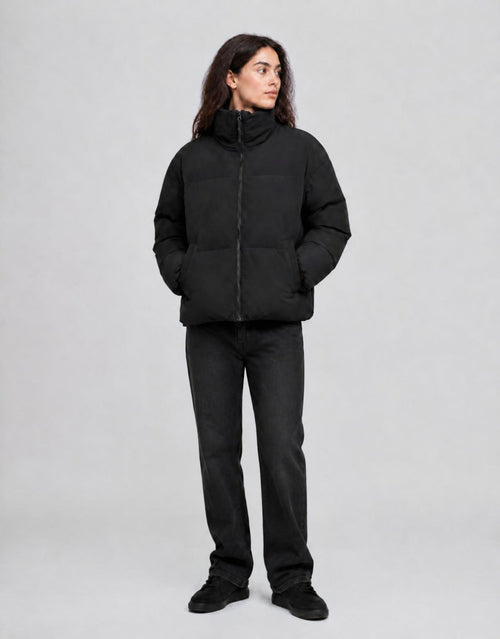 Schwarze wattierte Jacke Refron von MSCH Copenhagen mit kurzer Bomber-Silhouette, hohem Stehkragen und Reißverschluss am Model