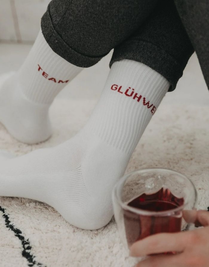 Socken Team Glühwein von Eulenschnitt – weiche Baumwollsocken mit eingesticktem Schriftzug „Team Glühwein“ in festlichem Design.