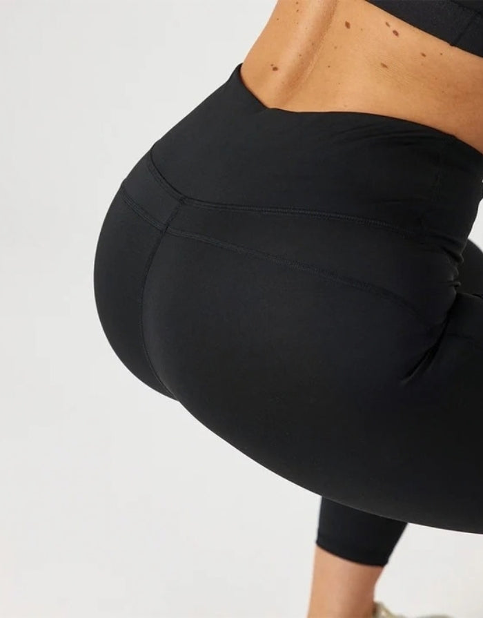 High-Waist-Leggings von SNOCKS mit hohem Bund aus flexiblem, blickdichtem Material mit recyceltem Polyester am Model mitHintern im Detail