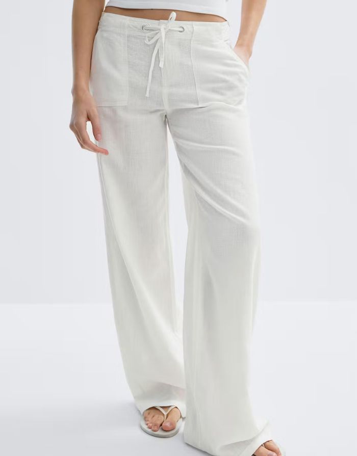 Gina Tricot weiße Leinenhose mit Bindeband, geradem Bein und lockerer Passform am Modell von vorne