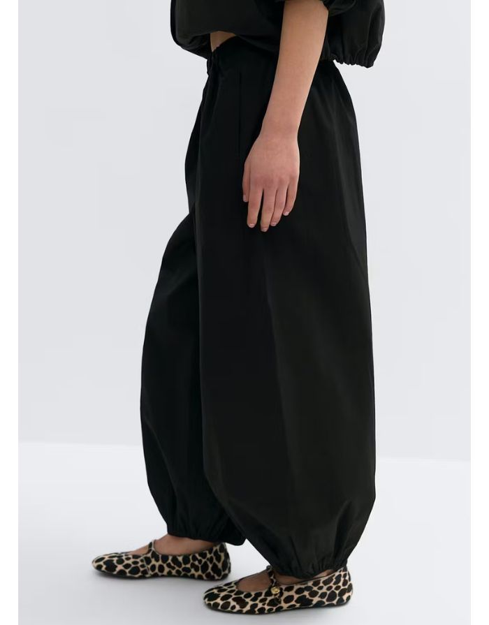 Gina Tricot schwarze Ballonhose aus Baumwolle mit elastischem Bund und weitem Bein am Model von der Seite