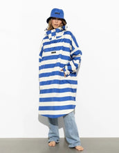 Laden Sie das Bild in den Galerie-Viewer, Raincoat Bold Stripes Blue/Sand von VIVI MARI – wasserdichtes Cape aus recyceltem Polyester in Oversize-Passform mit Kapuze, Klettverschluss-Manschetten und seitlichen Taschen, nachhaltig und funktional für Stadt, Fahrrad und Alltag
