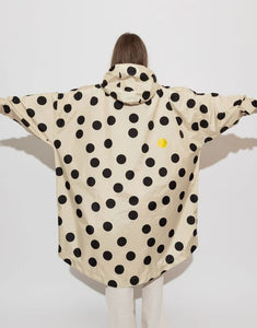 Raincoat Bold Stripes Dots Black/Sand von VIVI MARI: Langer, wasserdichter Regenmantel im Streifen-Design, oversized geschnitten mit Kapuze, Knopfleiste, Klettverschluss-Manschetten und praktischen Taschen – nachhaltig aus recyceltem Polyester gefertigt.