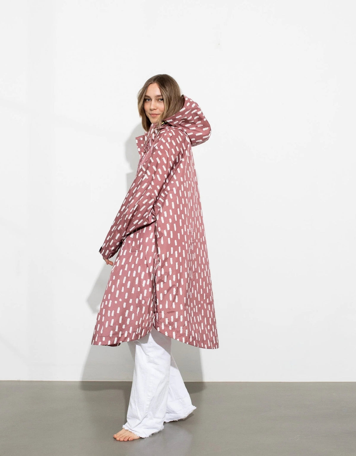 VIVI MARI Raincoat im Drops-Design in Mauve und Weiß mit Oversize-Passform, Kapuze und abgerundetem Saum.