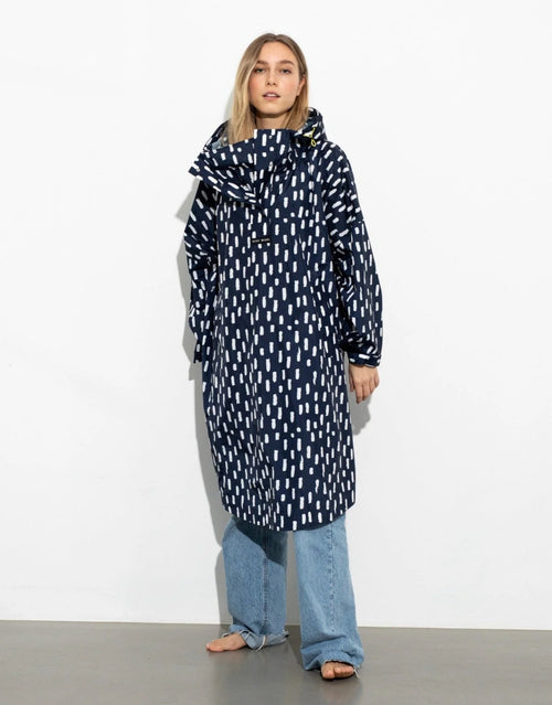 VIVI MARI Raincoat im Drops-Design in Navy und Weiß mit Oversize-Passform, Kapuze und abgerundetem Saum.