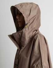 Laden Sie das Bild in den Galerie-Viewer, VIVI MARI Raincoat in Dark Mushroom, wasserdichtes Oversize Cape mit Kapuze.
