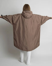 Laden Sie das Bild in den Galerie-Viewer, VIVI MARI Raincoat in Dark Mushroom, wasserdichtes Oversize Cape mit Kapuze.
