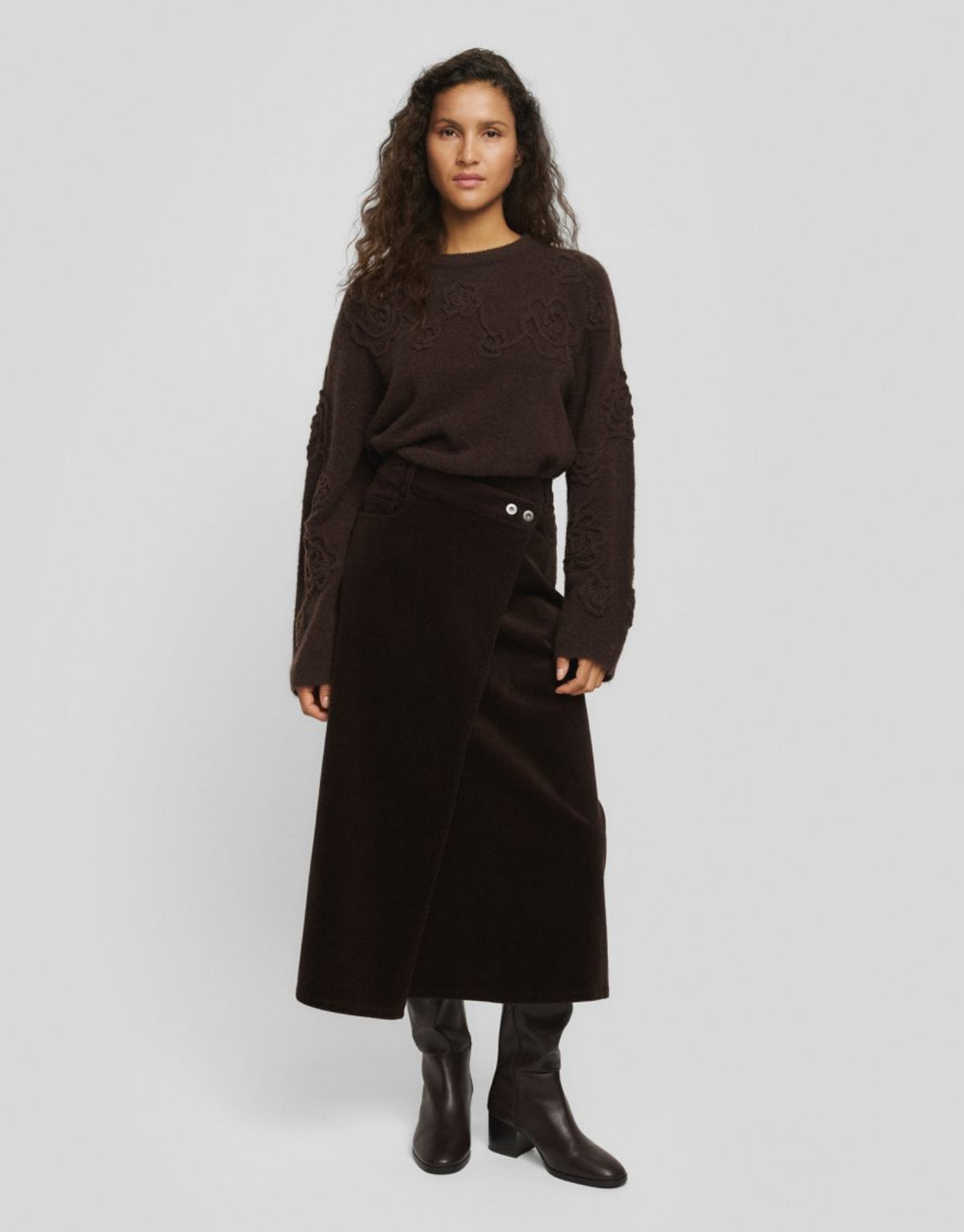 Dunkelbrauner&nbsp;Filippa Cordrock von MSCH Copenhagen in Midi-Länge mit leicht ausgestellter Silhouette, asymmetrischen Knöpfen und überlappender Vorderseite am Model