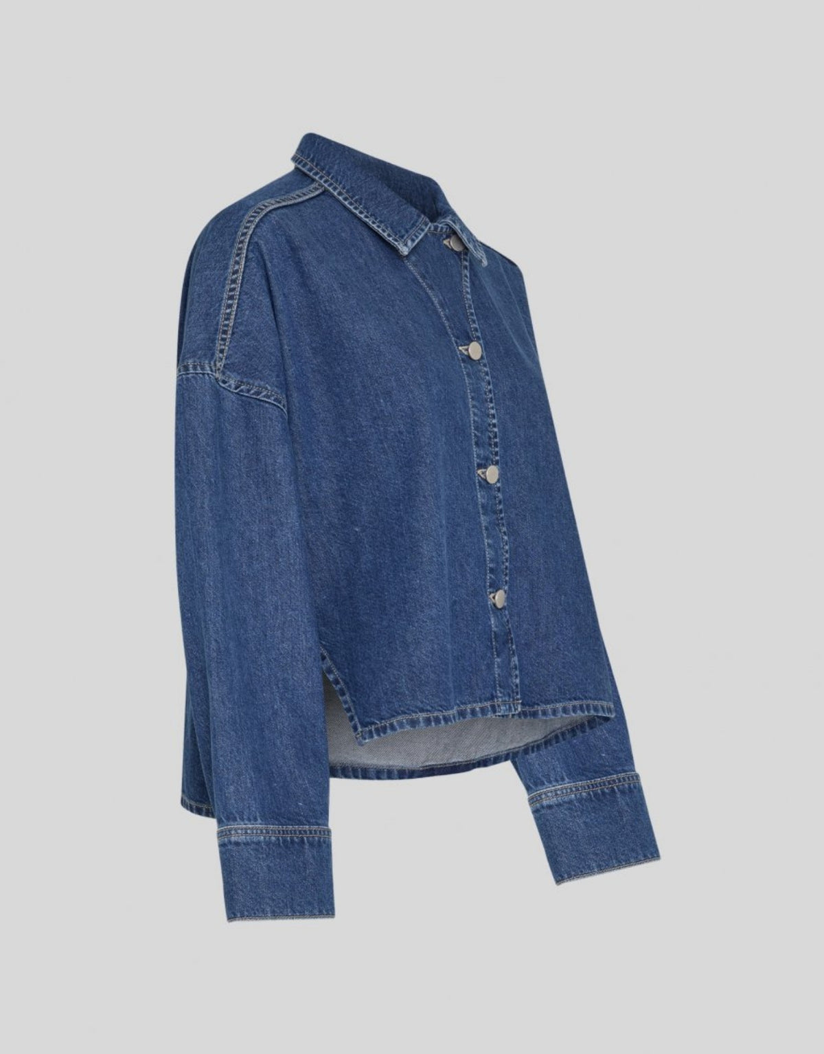 Mittelblaues Loa Lis Denim Shirt von MSCH Copenhagen aus Baumwolle mit lockerer, kurzer Boxy-Passform, klassischem Hemdkragen, Knopfleiste und langen Ärmeln als Freisteller von der Seite