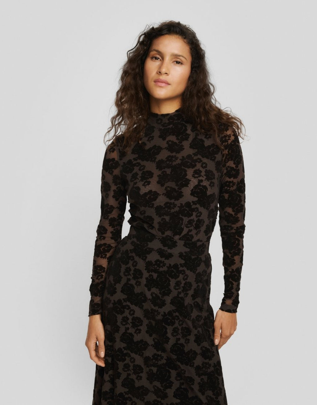 Dunkelbraunes Isa Illenora Shirt von MSCH Copenhagen aus transparentem Mesh mit schwarzem floralem Flockprint, Rollkragen und langen Ärmeln am Model