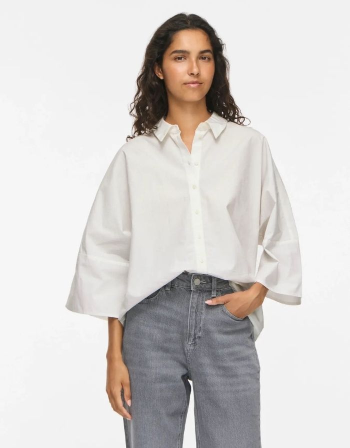 Weiße Bluse Vijuno Shirt 2/4 von VILA mit Hemdkragen, lockerer Passform, 2/4-Ärmeln und Knopfleiste aus 100 % Baumwolle am Model von vorne