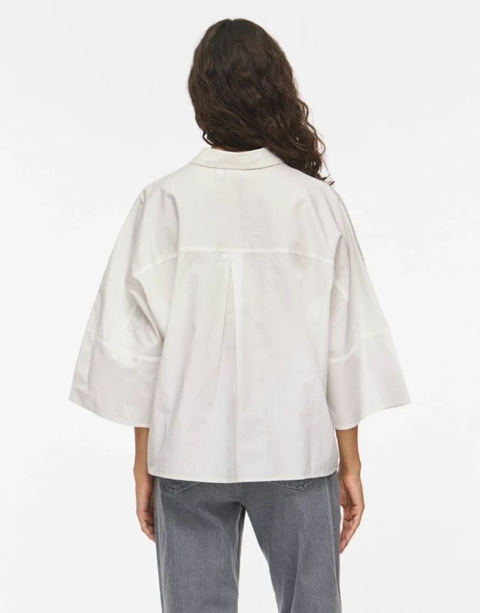 Weiße Bluse Vijuno Shirt 2/4 von VILA mit Hemdkragen, lockerer Passform, 2/4-Ärmeln und Knopfleiste aus 100 % Baumwolle am Model von hinten