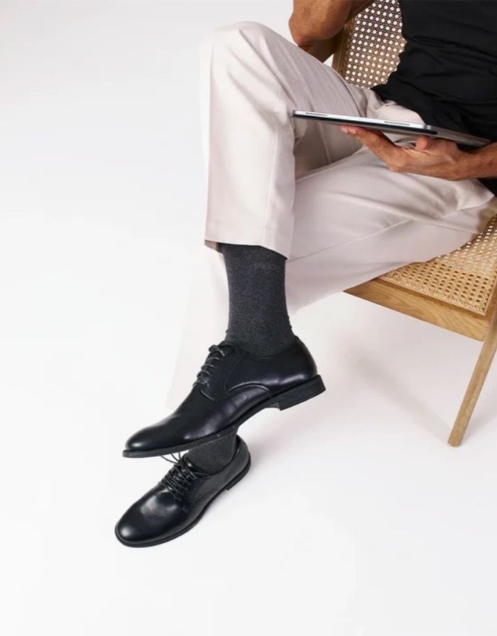 Schwarze Business-Socken von Snocks aus Bio-Baumwolle mit komfortabler Passform und knielanger Form für den Büroalltag  am Model