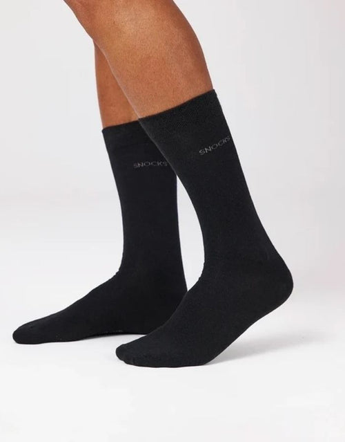 Schwarze Business-Socken von Snocks aus Bio-Baumwolle mit komfortabler Passform und knielanger Form für den Büroalltag am Model von der Seite