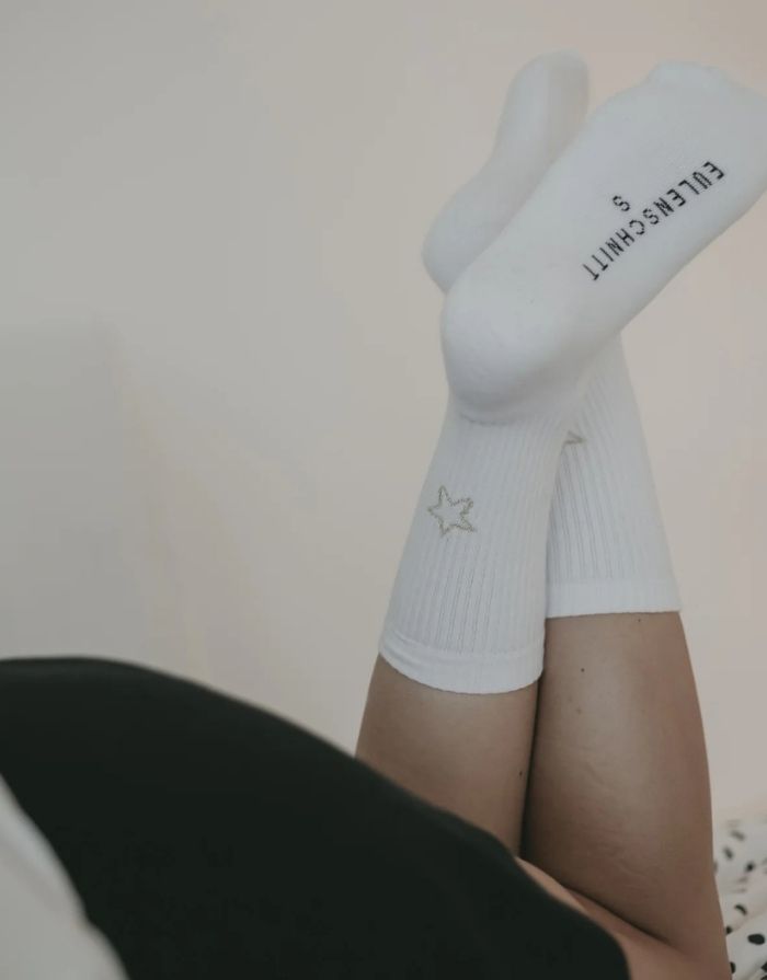 Weiße Socken Stern von Eulenschnitt mit goldener Sternstickerei, gefertigt aus Bio-Baumwolle, recyceltem Polyamid und Elastan.