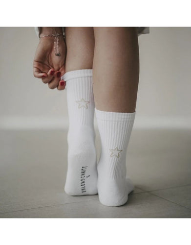 Weiße Socken Stern von Eulenschnitt mit goldener Sternstickerei, gefertigt aus Bio-Baumwolle, recyceltem Polyamid und Elastan.
