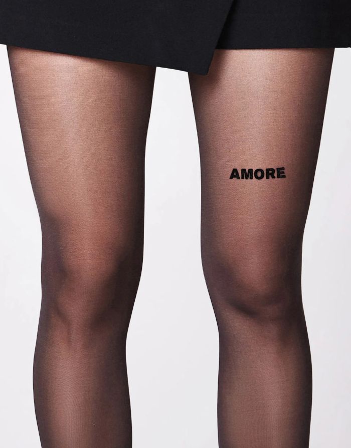 Schwarze semi-transparente Statement-Strumpfhose Amore von saint sass mit 40 DEN und Amore-Schriftzug am linken vorderen Oberschenkel.