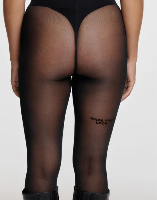 Schwarze semi-transparente Statement-Strumpfhose Made You Look von saint sass mit 40 DEN und Schriftzug am rechten hinteren Oberschenkel.