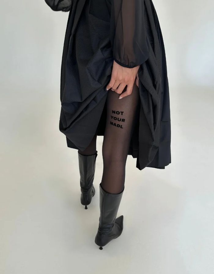  Schwarze semi-transparente Statement-Strumpfhose Not Your Madl von saint sass mit 40 DEN und Schriftzug am rechten hinteren Oberschenkel.