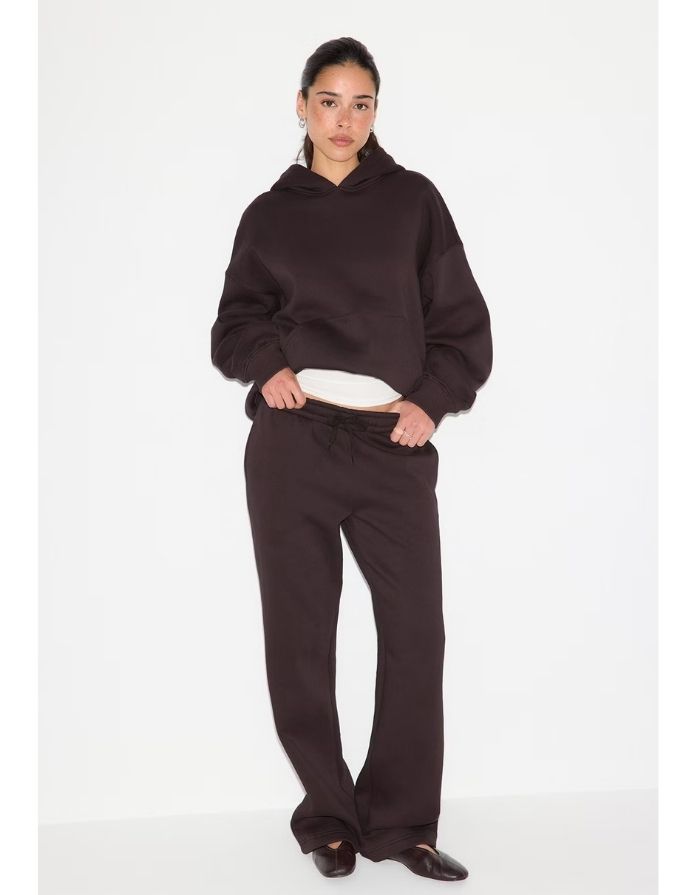 Gina Tricot Iconic Sweat Pants in Chocolate Plum aus Baumwollmischung mit weitem geradem Bein, elastischem Bund, Bindeband und Seitentaschen am Model von vorne 